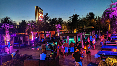 Guests at DayDream Pool Club at The M Resort party during a nighttime event.