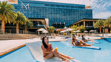 women relaxing on chairs in M Pool with drinks